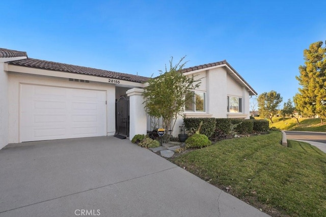 view of front of property featuring an attached garage, driveway, a tiled roof, stucco siding, and a front yard