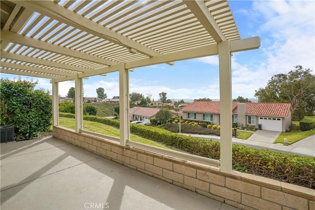 view of patio with a residential view, driveway, an attached garage, and a pergola