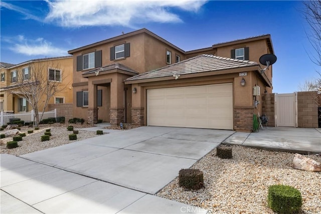 view of front of house featuring an attached garage, fence, a tile roof, driveway, and stucco siding