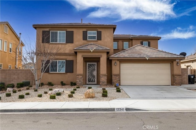 view of front of home with a garage, driveway, fence, and stucco siding