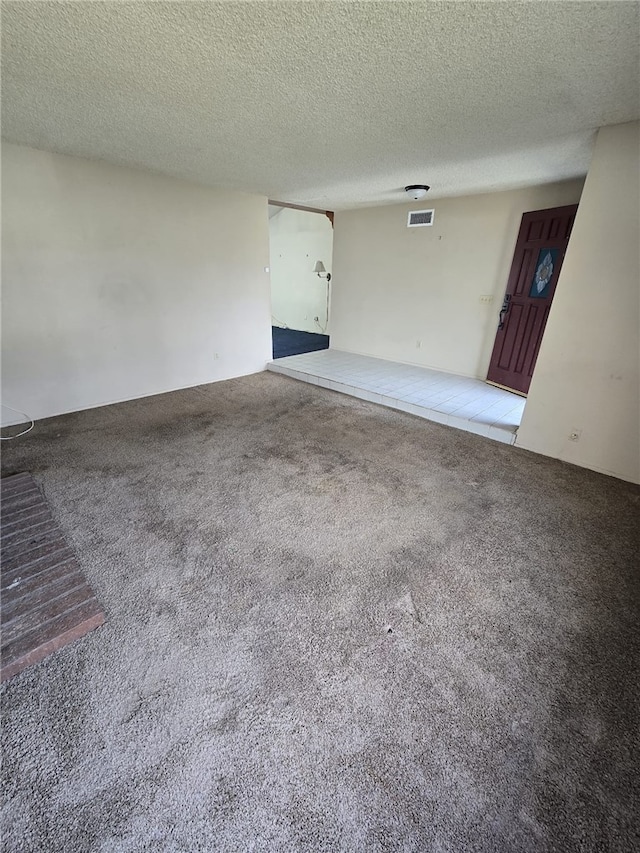 interior space with visible vents, carpet, and a textured ceiling