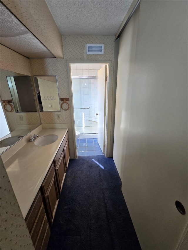 bathroom featuring visible vents, toilet, a textured ceiling, vanity, and wallpapered walls