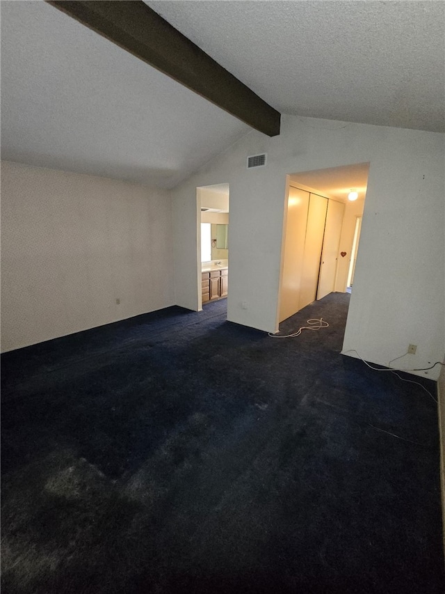 unfurnished room featuring carpet flooring, visible vents, and lofted ceiling with beams