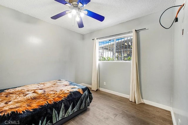 bedroom featuring a textured ceiling, hardwood / wood-style flooring, and ceiling fan