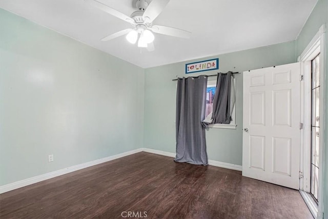 unfurnished bedroom with ceiling fan and dark wood-type flooring