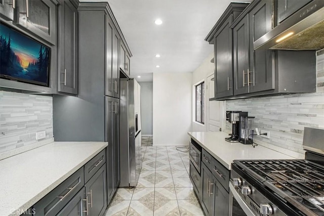 kitchen featuring light tile patterned flooring, wall chimney exhaust hood, stainless steel appliances, and backsplash