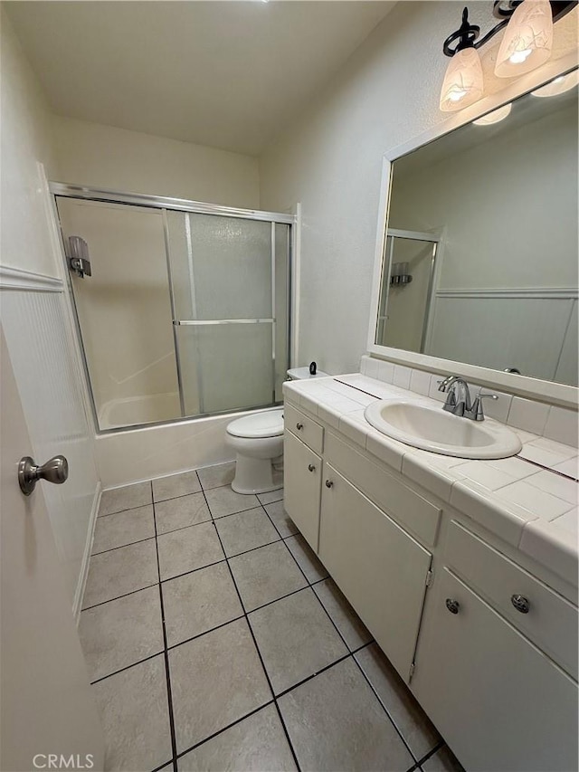 749 Junipero Ct, Merced, CA 95348 - full bath featuring shower / bath combination with glass door, toilet, tile patterned flooring, and vanity