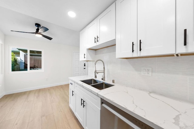 kitchen with sink, white cabinetry, tasteful backsplash, and light stone countertops