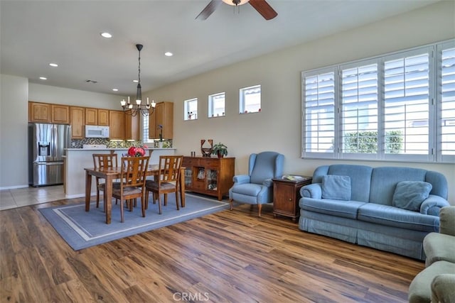 dining space featuring ceiling fan with notable chandelier, dark wood-style flooring, and recessed lighting