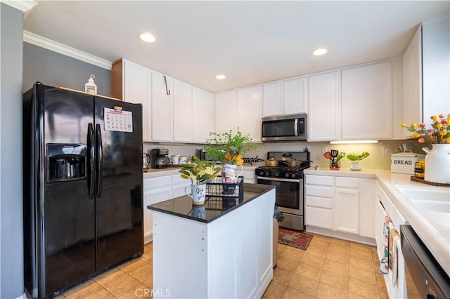 kitchen featuring appliances with stainless steel finishes, ornamental molding, white cabinets, backsplash, and a kitchen island