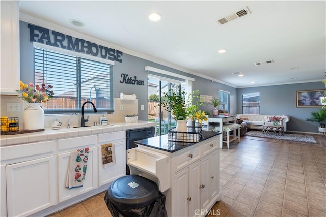 kitchen with tile counters, sink, ornamental molding, light tile patterned floors, and white cabinets