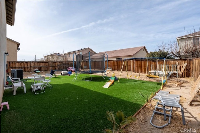 view of yard featuring a trampoline, central AC, and a playground