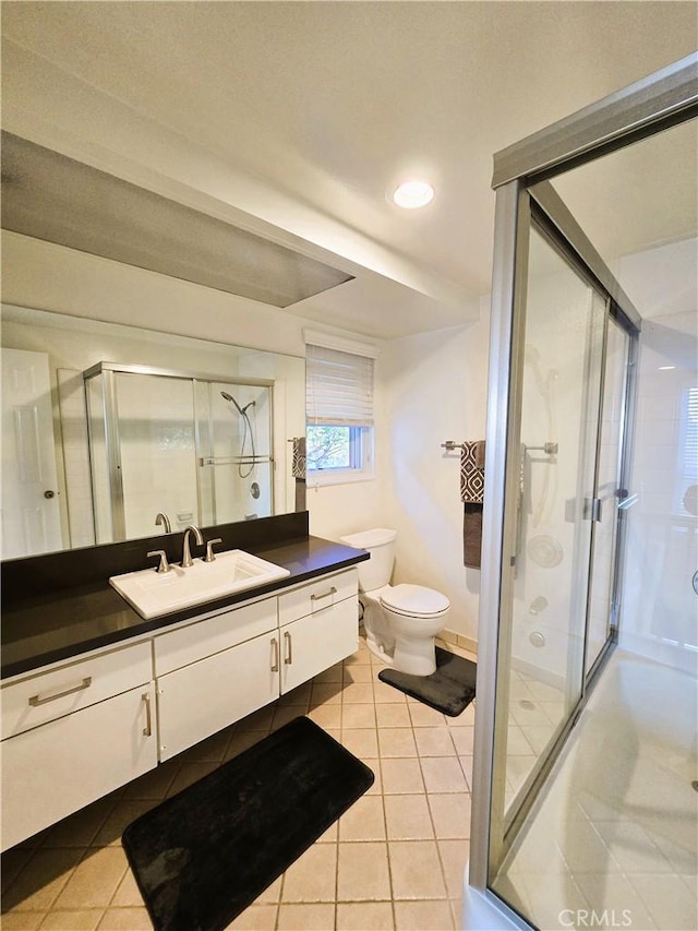 full bath with toilet, vanity, a shower stall, and tile patterned floors