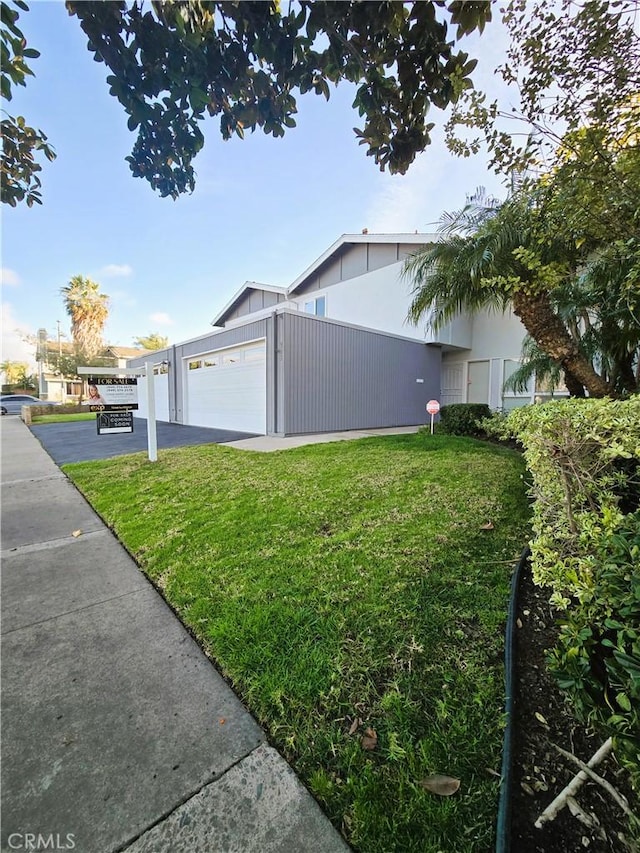 view of home's exterior with a garage and a yard