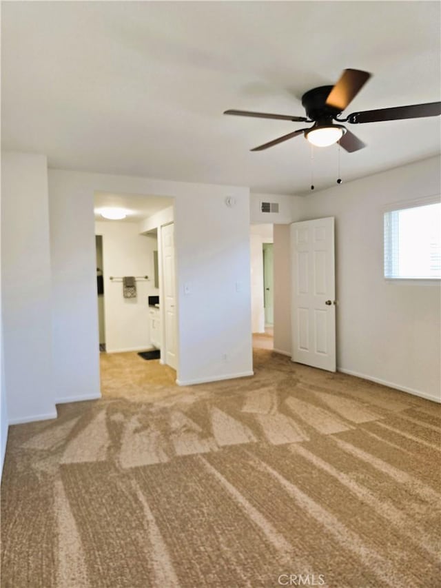 carpeted empty room featuring ceiling fan, visible vents, and baseboards