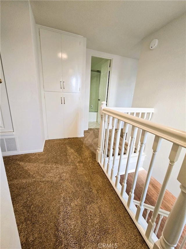 hallway featuring carpet and visible vents