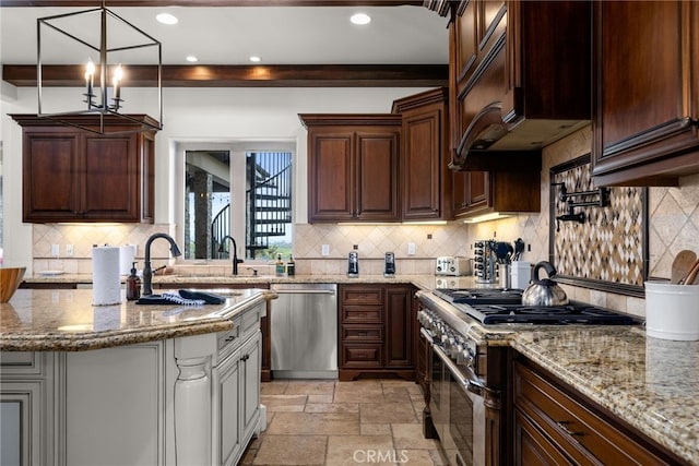 kitchen with appliances with stainless steel finishes, dark brown cabinets, light stone countertops, and pendant lighting