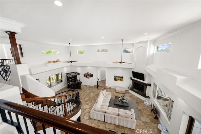 living room featuring ceiling fan, plenty of natural light, and ornate columns