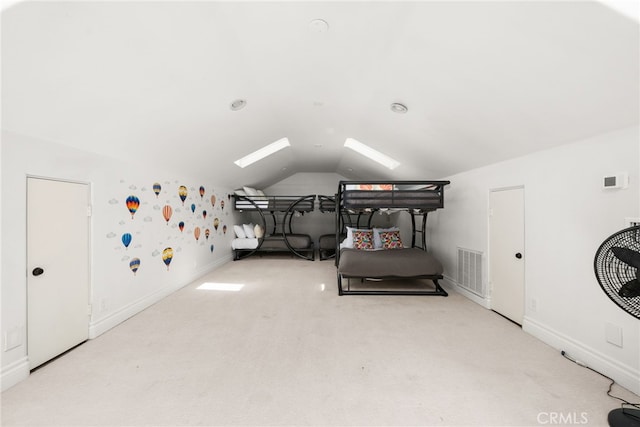 carpeted bedroom featuring vaulted ceiling with skylight