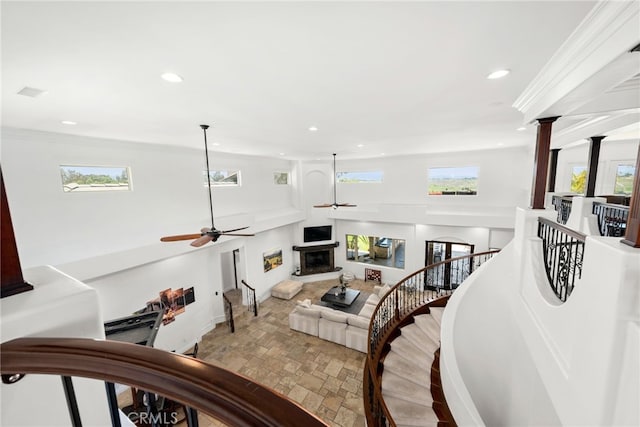 stairs featuring crown molding and ceiling fan