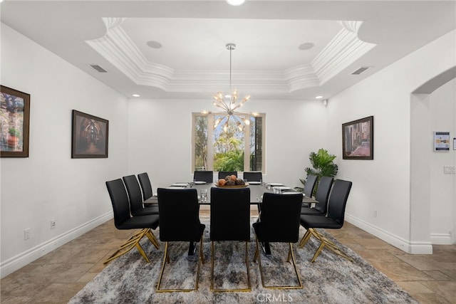 dining room with a tray ceiling, ornamental molding, and an inviting chandelier