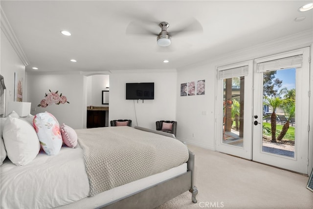 bedroom with crown molding, connected bathroom, light carpet, french doors, and access to exterior