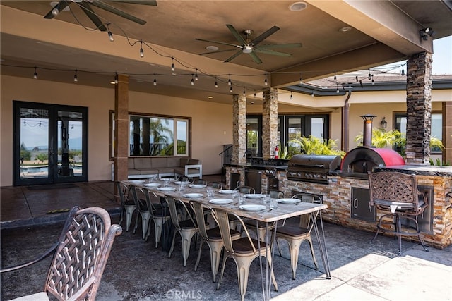 view of patio / terrace with ceiling fan, a bar, and grilling area