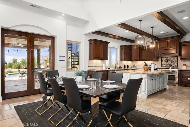 dining room with beam ceiling, sink, and an inviting chandelier