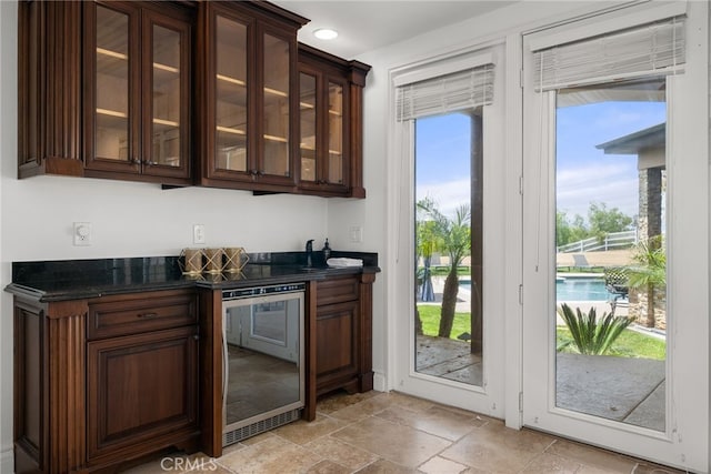 bar featuring dark brown cabinets and wine cooler