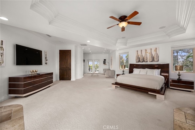 carpeted bedroom with a raised ceiling, ceiling fan, and crown molding