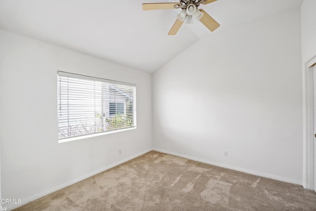 empty room featuring lofted ceiling, baseboards, a ceiling fan, and light colored carpet