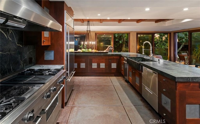 kitchen featuring tasteful backsplash, range hood, stainless steel appliances, a sink, and recessed lighting