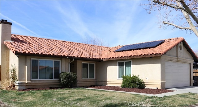 view of front of house featuring a garage, solar panels, and a front lawn