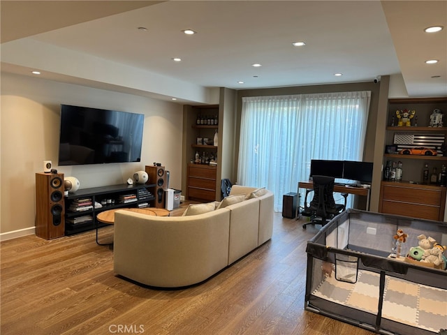 living room with recessed lighting, baseboards, and wood finished floors