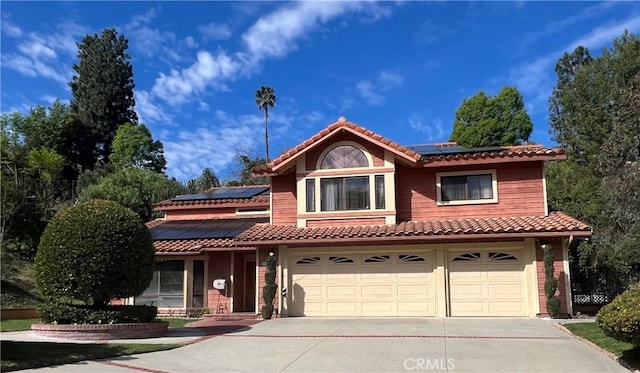 view of front of property featuring a garage and solar panels