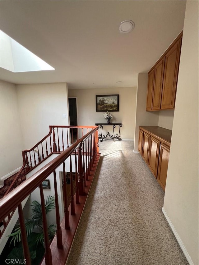 hall featuring a skylight and carpet flooring