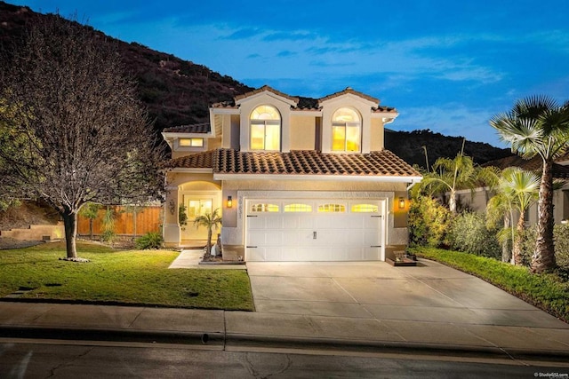 mediterranean / spanish-style home with a tile roof, a front lawn, and stucco siding