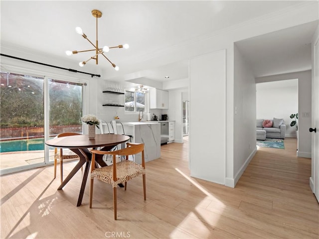 dining room with light hardwood / wood-style flooring and a notable chandelier