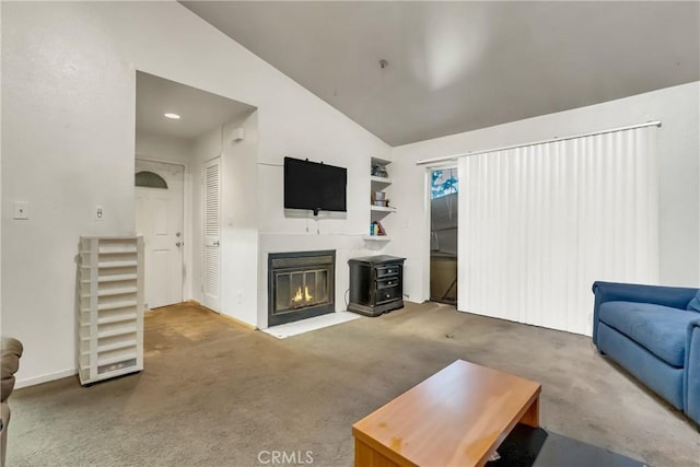 living area with a glass covered fireplace, lofted ceiling, carpet floors, and baseboards