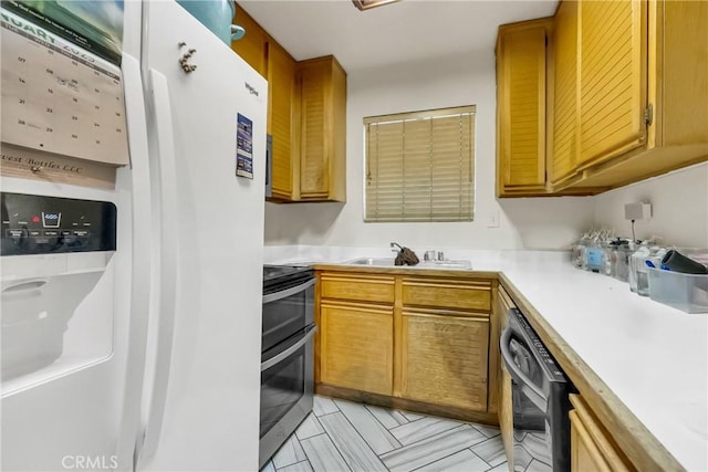 kitchen with a sink, white refrigerator with ice dispenser, dishwasher, light countertops, and range with two ovens