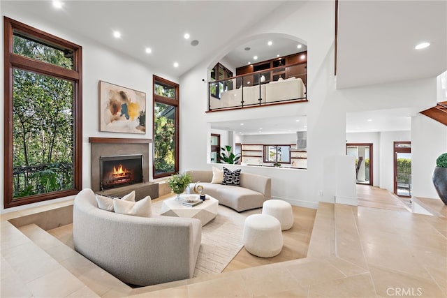 2907 Cliff Dr, Newport Beach, CA 92663 - living area with recessed lighting, a warm lit fireplace, a high ceiling, light tile patterned floors, and baseboards