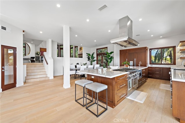 2907 Cliff Dr, Newport Beach, CA 92663 - kitchen featuring island range hood, range with two ovens, light countertops, light wood-type flooring, and a large island