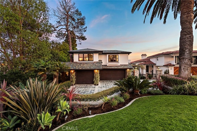 2907 Cliff Dr, Newport Beach, CA 92663 - view of front of property featuring stucco siding, an attached garage, a yard, and stone siding