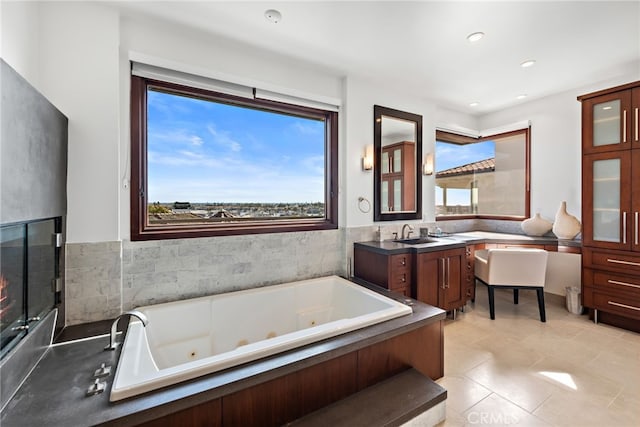 bathroom featuring a washtub, tile patterned floors, and vanity