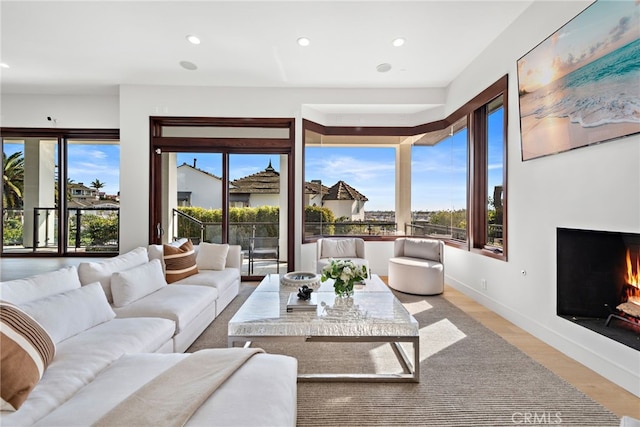 2907 Cliff Dr, Newport Beach, CA 92663 - living room featuring recessed lighting, a warm lit fireplace, light wood-style floors, and baseboards