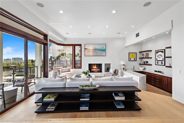 living room featuring bar area and light hardwood / wood-style floors