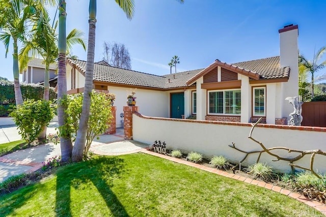 mediterranean / spanish house featuring a front lawn