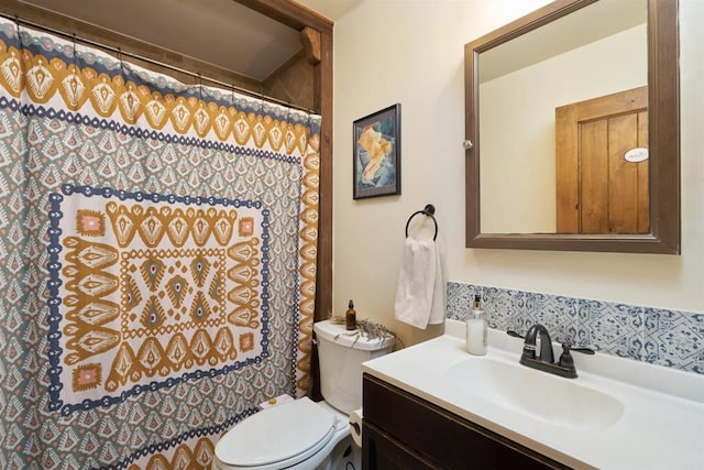 bathroom featuring toilet, vanity, and a shower with curtain