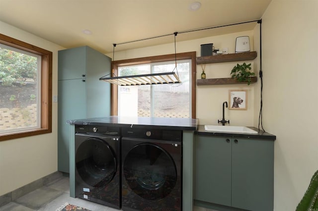 clothes washing area with cabinets, sink, and washer and clothes dryer