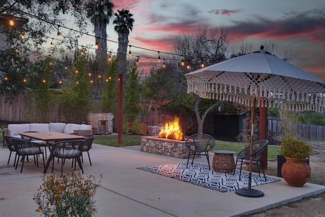 patio terrace at dusk featuring an outdoor living space with a fire pit